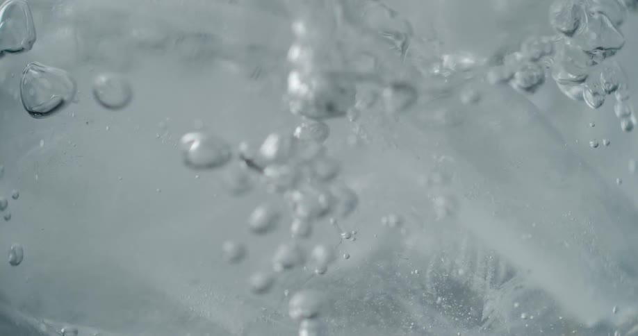 The liquid is poured over the ice and begins to fizz