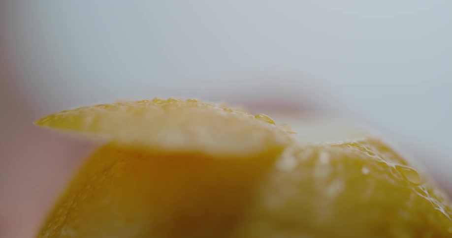 Close up of sharp knife cutting lemon peel