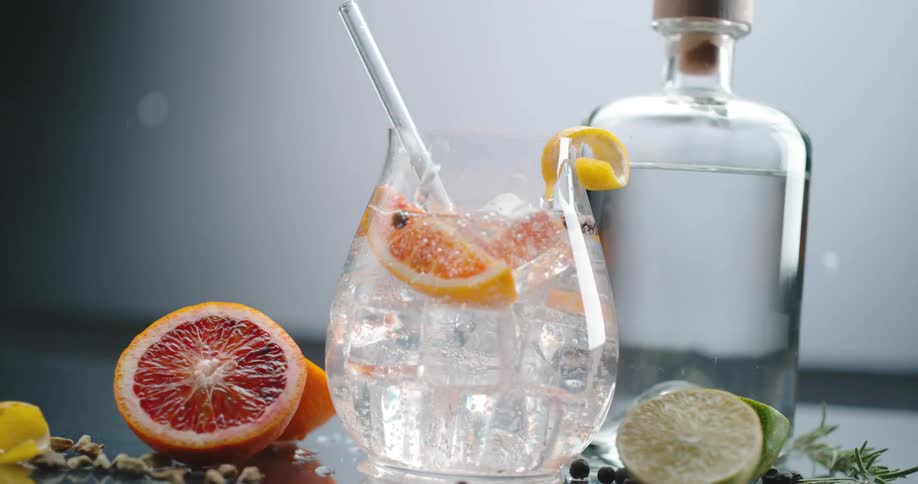 Clear crystal ice cubes pouring on a cocktail inside a glass or goblet