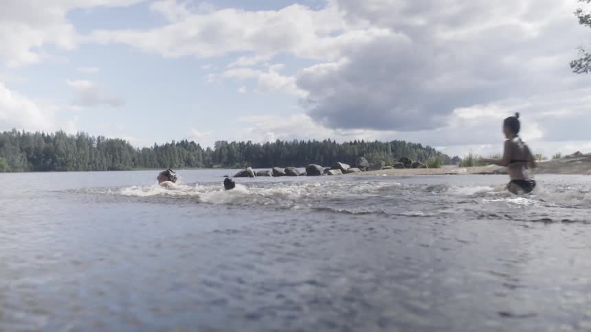 People run in the water and dive in