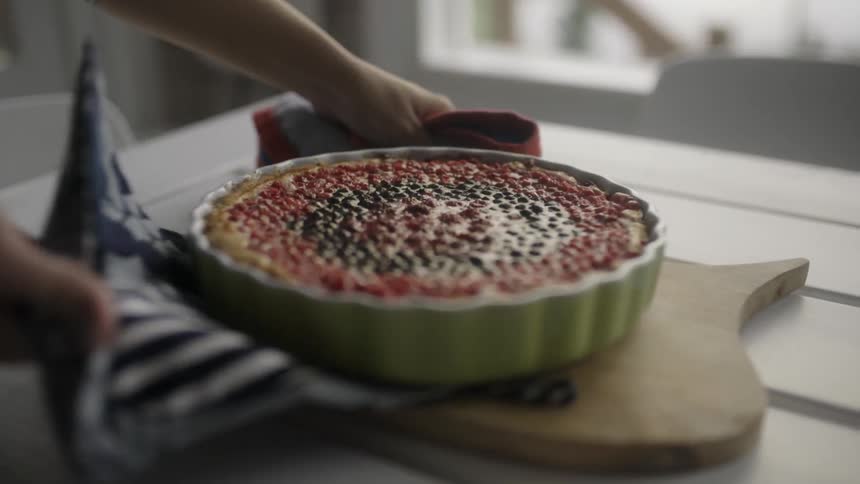 A person puts a pastry on a tray