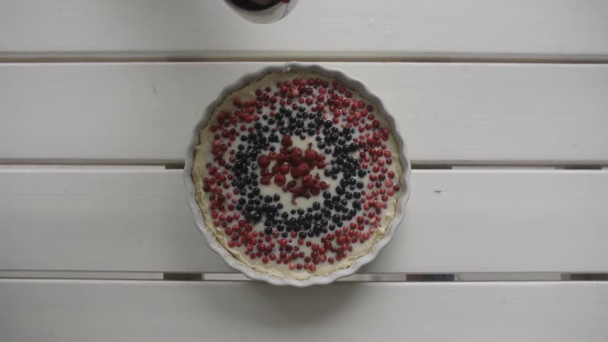 A woman placing berries in a pie shell