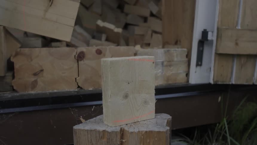 An axe swings breaking a small board