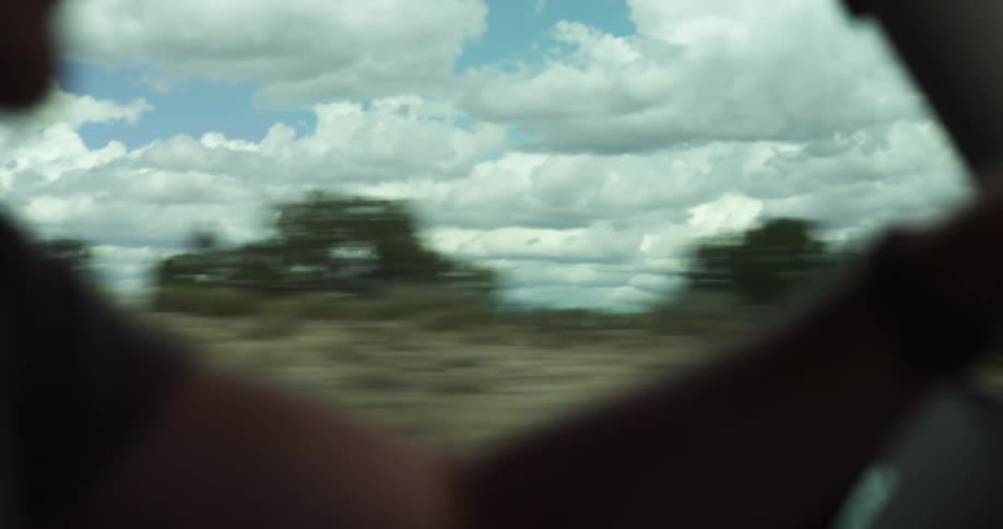 A person driving a car down a highway in the desert