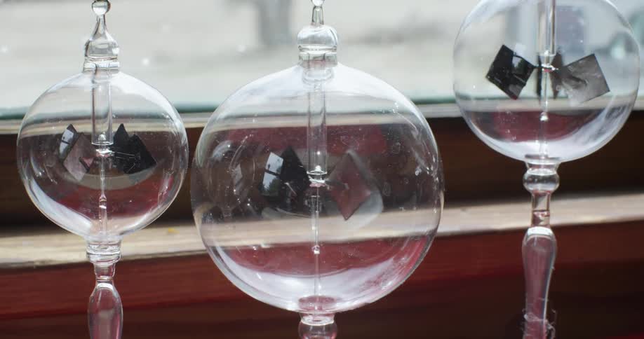 Pieces of metal rotating inside glass bulbs in a window sill