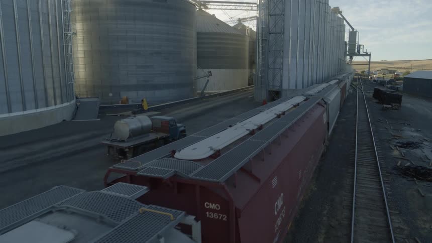 Skimming over the tops of hopper cars that are being loaded with grain for export