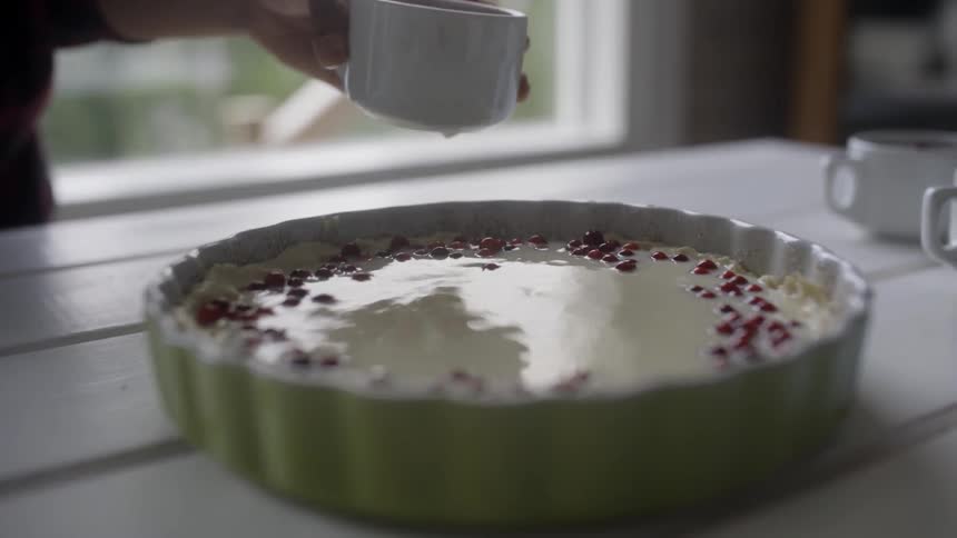 A hand give a cake on top icing