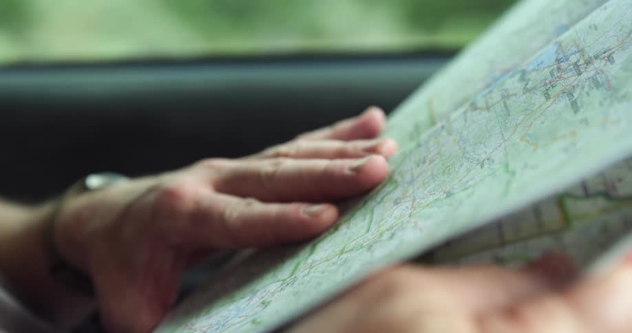 A person is reading a map in a car
