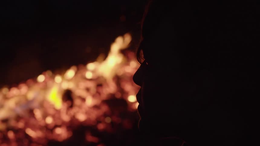 Silhouette of a persons head with fire and flames in the background