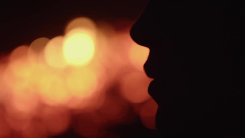 A person is standing near a bonfire