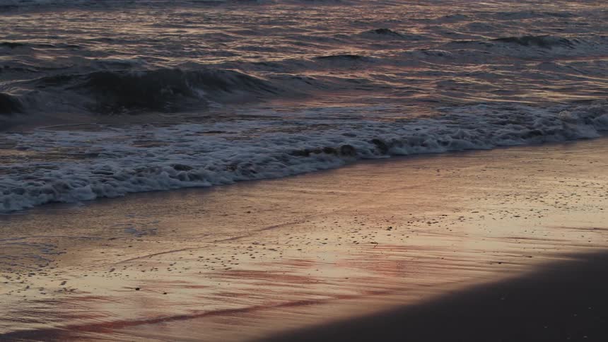 Shoreline as waves roll in on beach