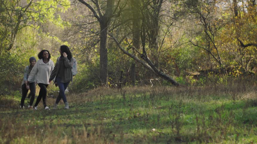 Three women hike on the field