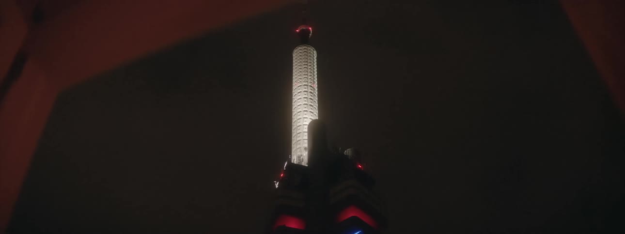 A tall tower glowing in a dark night sky