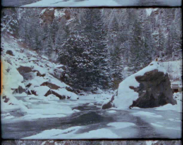 Vintage footage of a river flowing through a snow covered forest