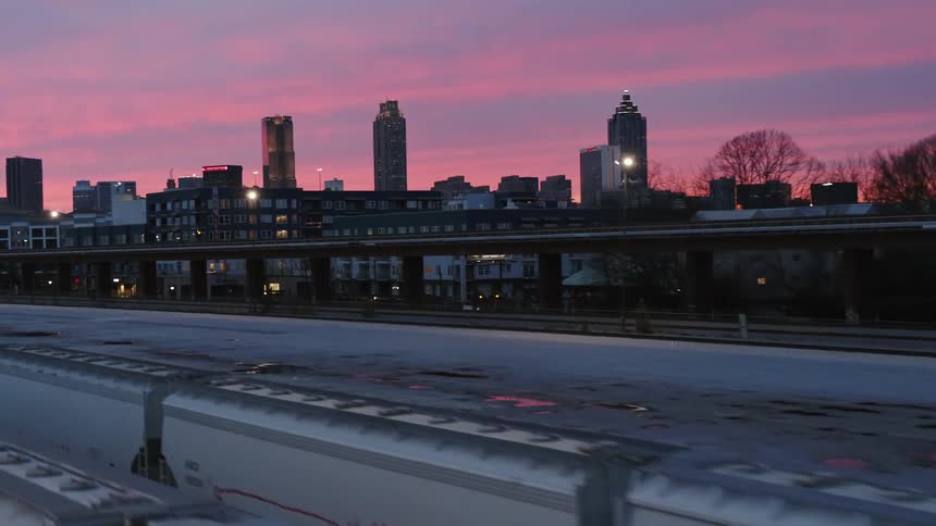 An aerial view of a train and city at sunset