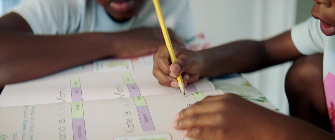 One person watches child work through homework