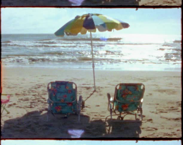 Beach chairs and umbrella near the shoreline at the beach