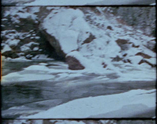 A bare chested man sits in a frozen lake