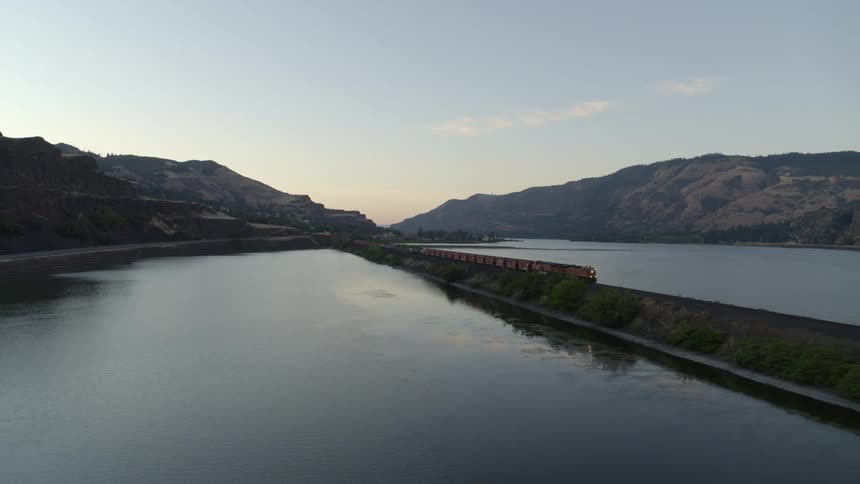 Leading a freight train as it travels quickly along a causeway surrounded by reflective water