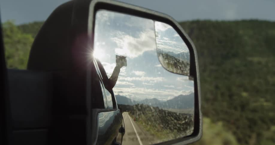 A person is hanging out the window filming with a phone