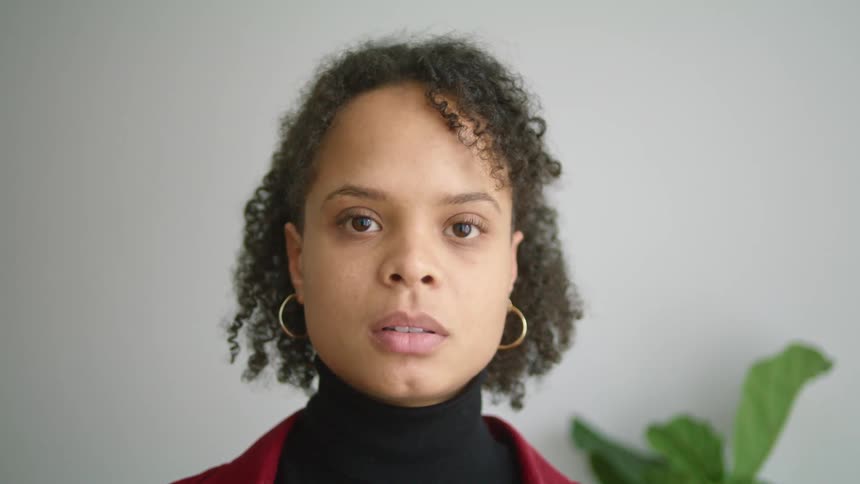 Young woman standing in a room looks up at the camera