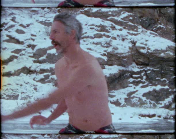 A man outside exercising with rocks ice and snow in the background