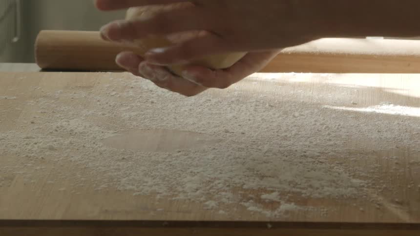 A person is rolling dough indoors