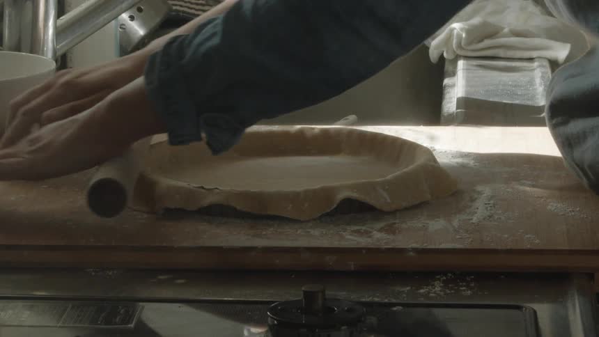 Rolling dough on a pie plate to make a pie crust