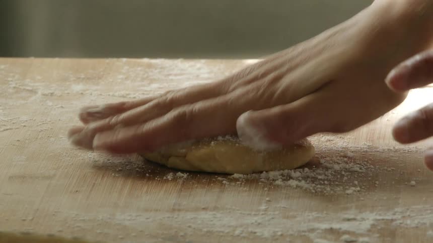 Sprinkling flour on a piece of dough and patting it in