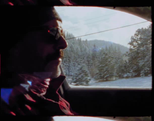 A man driving through a snowy forest on a sunny winter day