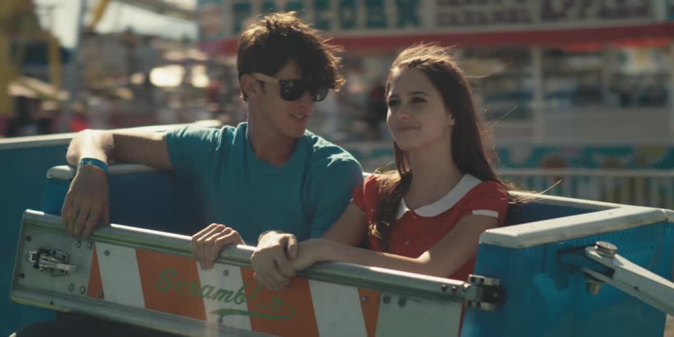 Young attractive pretty couple spends date riding an attraction in the carnival