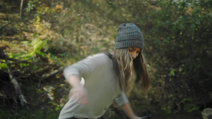 Young attractive woman hiking through a trail in the forest