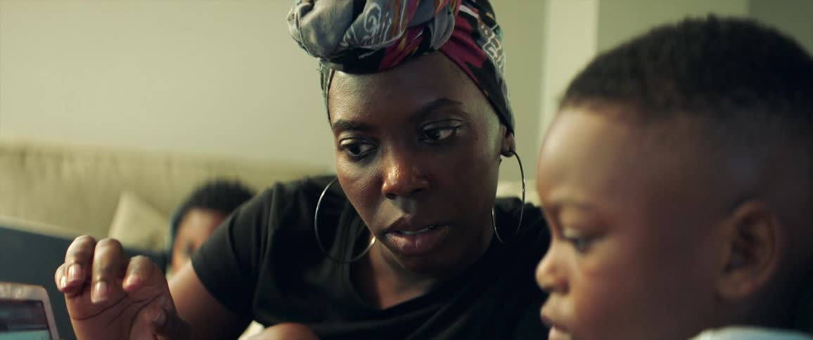 A woman is looking at a laptop with her son