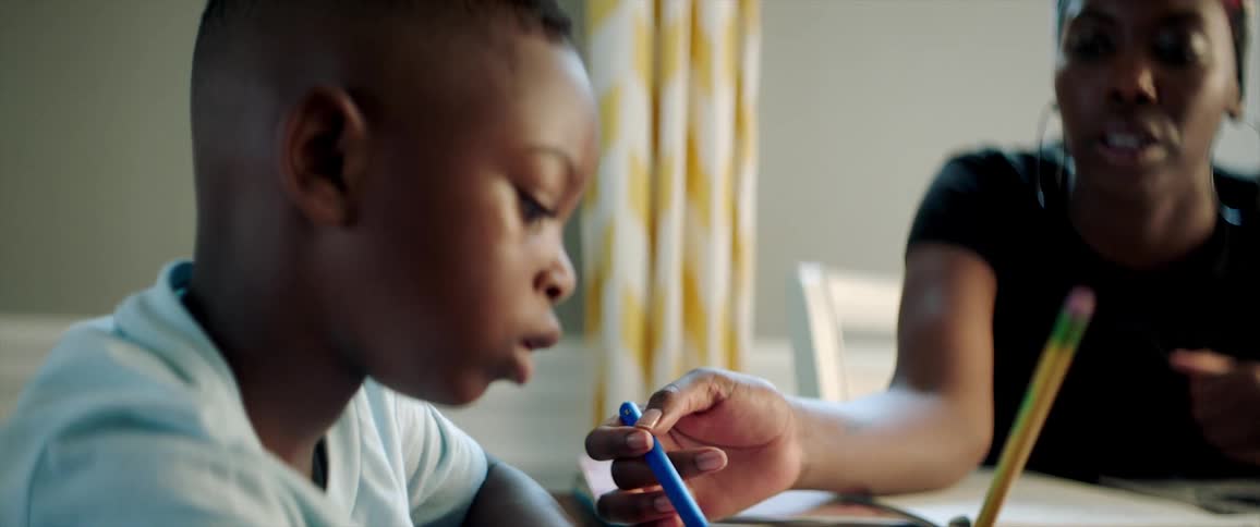 A young male student being tutored by a female adult