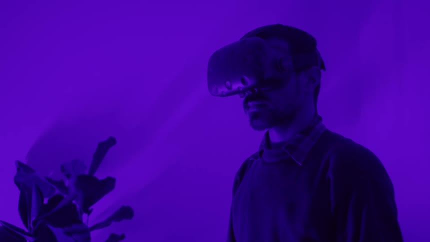 A man pulls his vr glasses down over his eyes then begins to reach for items with his hands