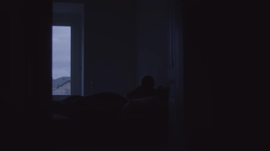 A man using a tablet on the bed turns it off and goes to sleep
