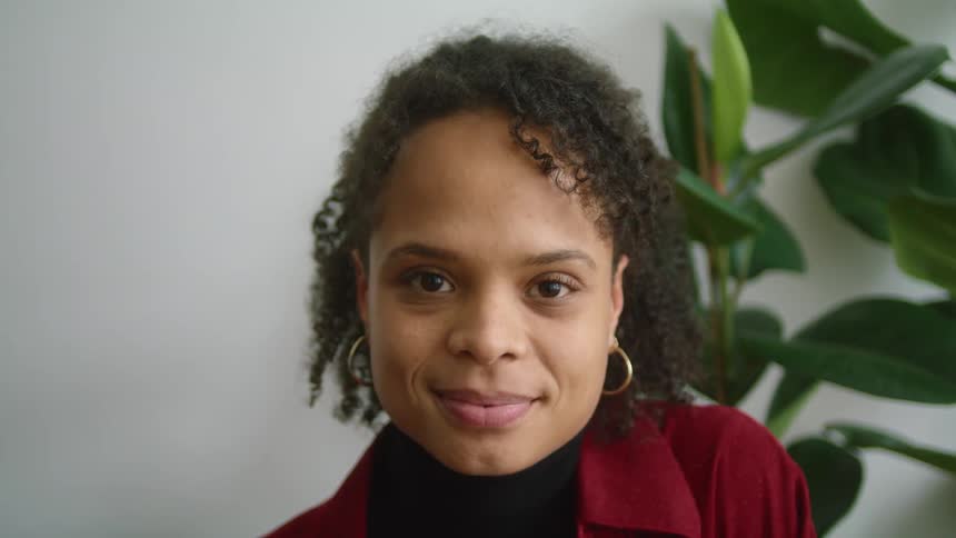 A woman lifts her head to smile into the camera