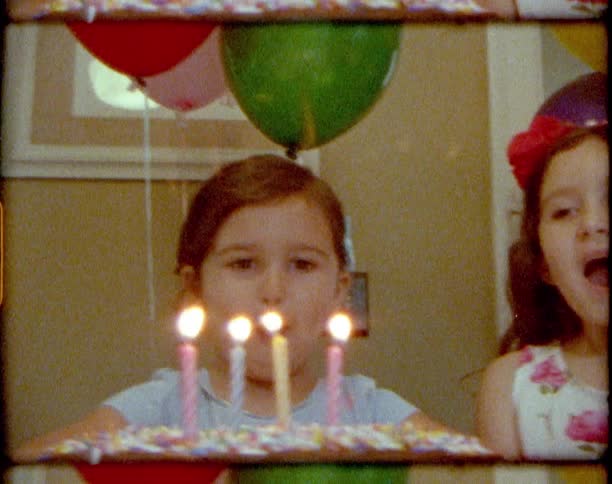 A child blowing out candles on a cake
