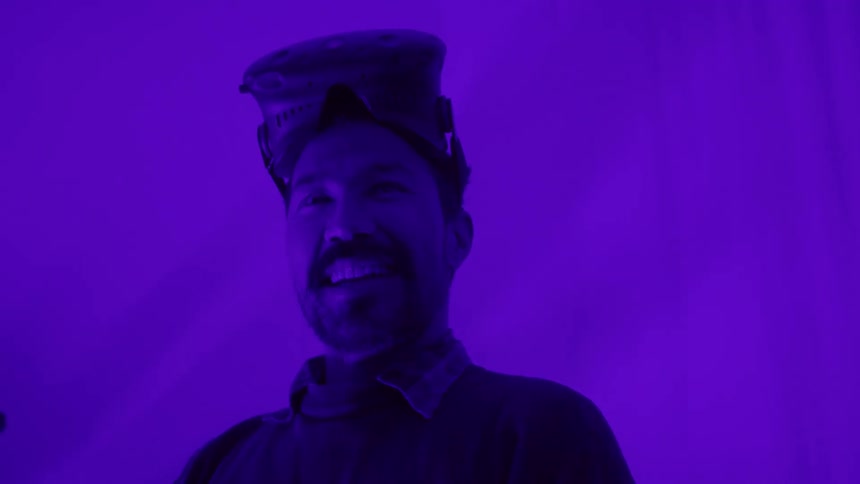 Man tinted purple removes vr goggles