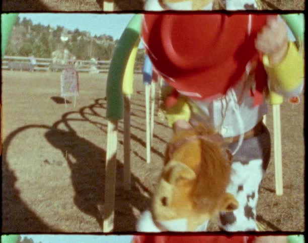 A young girl playing on a playground while wearing a cowgirl costume
