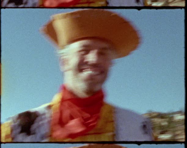 Adult man wearing a cheap cowboy costume playing with a bright shiny toy windmill