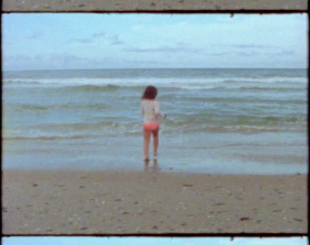 A child runs into the water on the beach