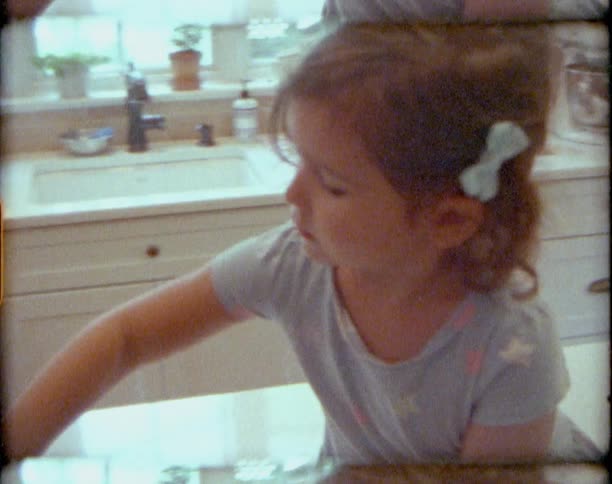Vintage film of two little girls stirring and eating batter at home