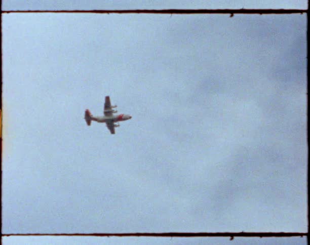 Vintage footage of an airplane flying in a cloudy sky