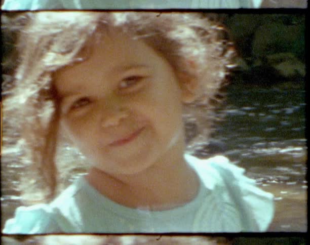 Vintage footage of a little girl playing in a river