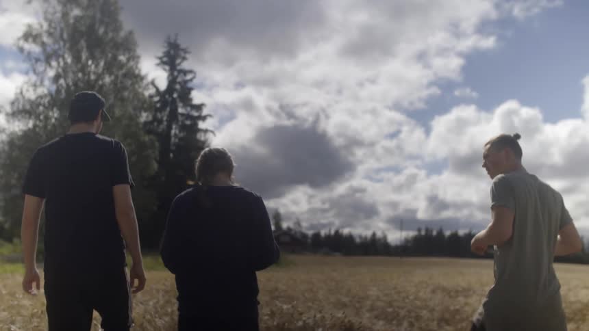 People walking through a rural field on a cloudy day