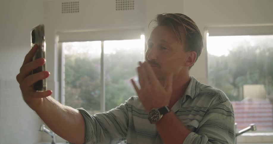 A man talking to another person on a smartphone