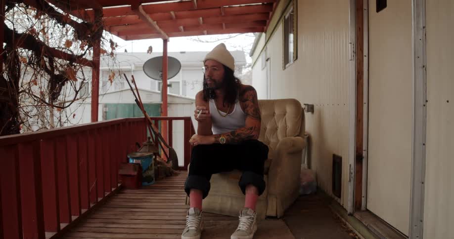 A man is sitting on a chair and smoking