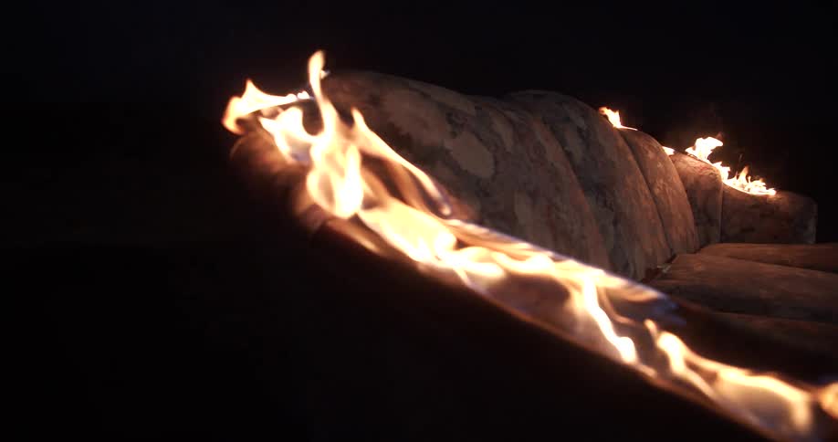 The couch is burning outside at night