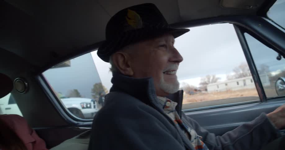 A man is smiling as he drives away